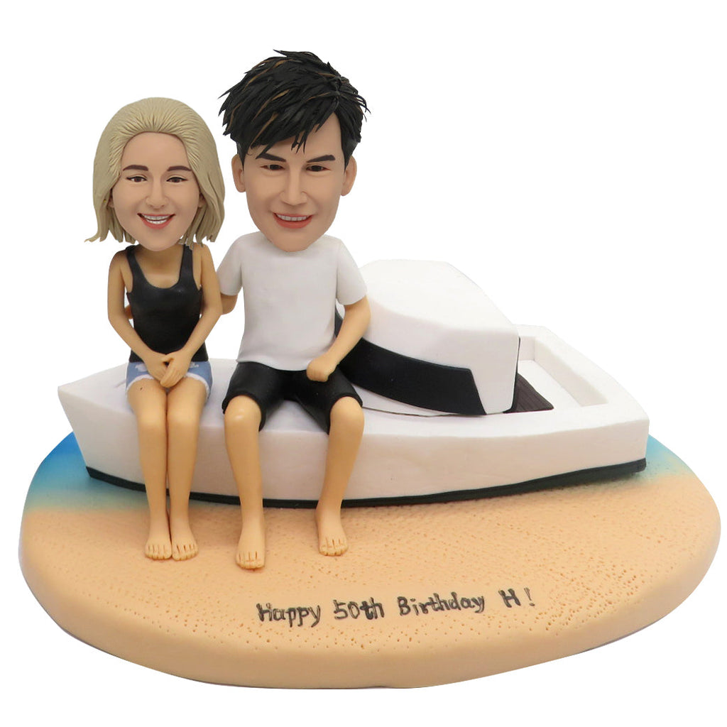 Coppia bobblehead sulla spiaggia con yacht