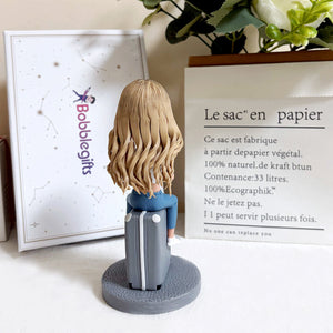Bobblehead personalizzato seduto su una valigia