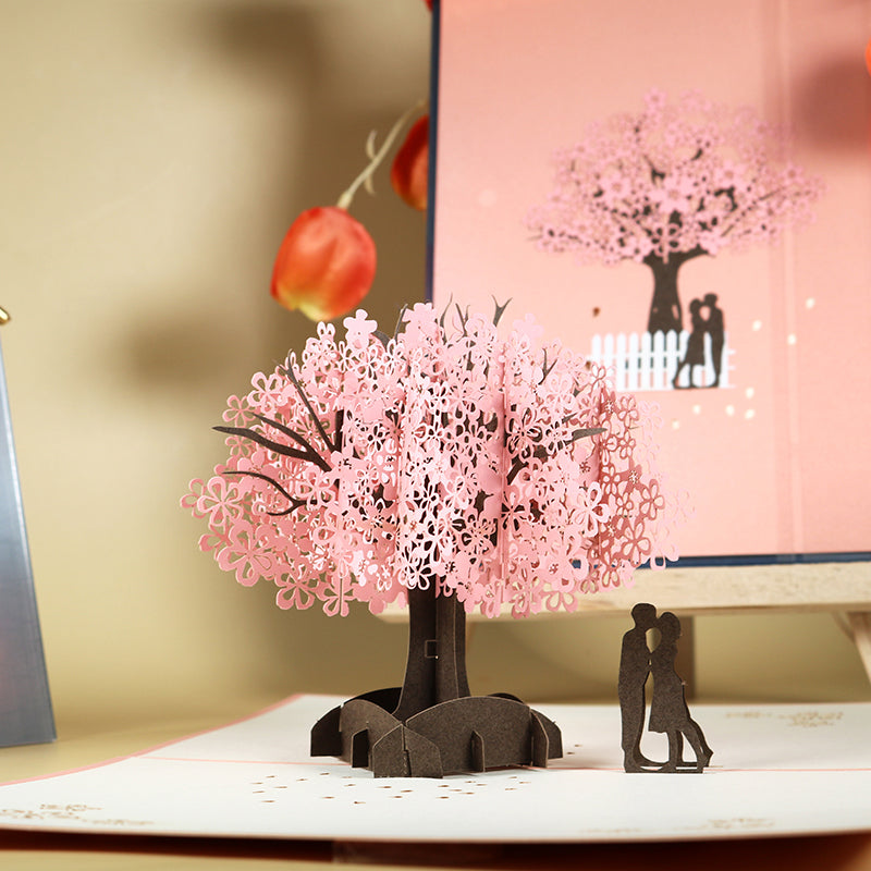 Biglietto d'auguri pop-up 3D con coppia romantica sotto un ciliegio