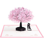 Biglietto d'auguri pop-up 3D con coppia romantica sotto un ciliegio